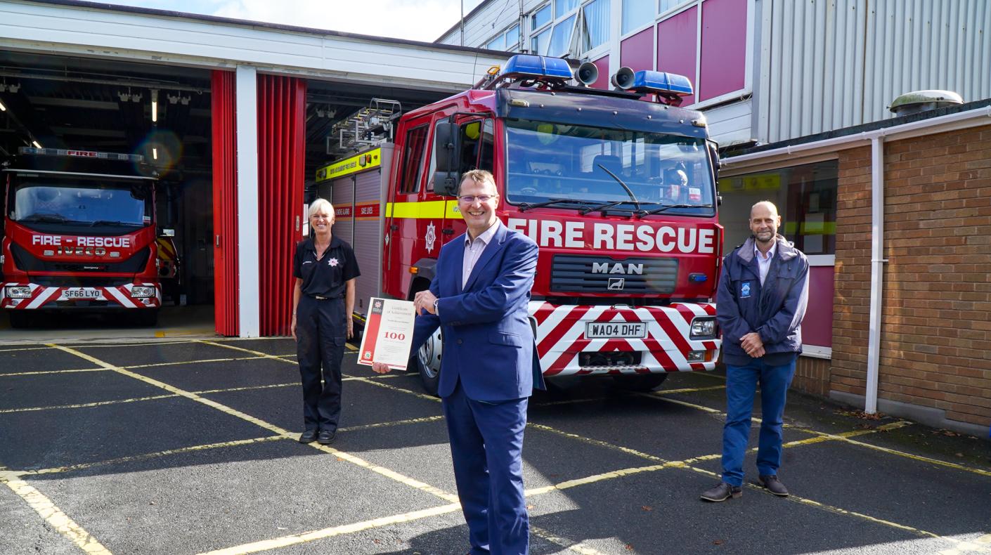 Mark Rostock receiving the 100 referrals certificate at Barnstaple Fire Station