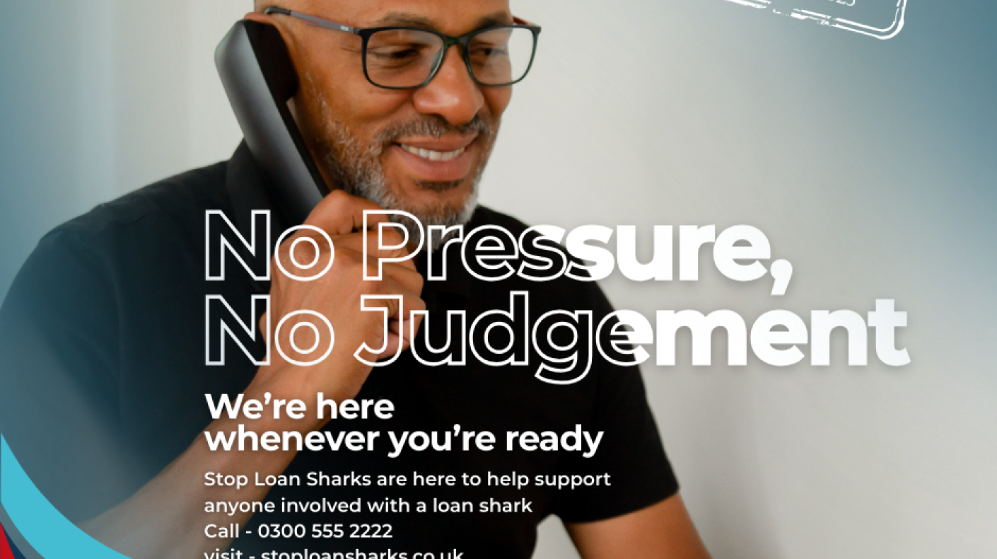A man smiling holding a telephone to his ear