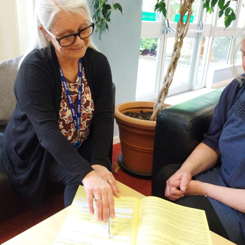 Our Financial Inclusion Officer sat helping a customer with a form
